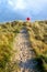 Sandy pathway running through grass sand dunes with a red life belt at the end of the pathway