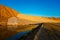 Sandy piles and blue sky near reservoir