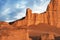 Sandy red rocks against the blue sky with white clouds in the desert of Iran. A small silhouette of a man against the backdrop of