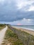 sandy roads along the ocean converging to one point, lighthouse at sunset, perspective view