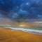 sandy sea beach under dramatic cloudy sky