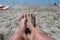 Sandy Serenity: Close-Up of Yellow Pedicured Feet Relaxing in Beach Sand