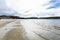 Sandy shore of the northern sea, hills, cloudy sky