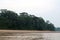 A sandy shoreline of the Tambopata River edged by the Amazon Rainforest in Peru at sunrise