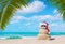 Sandy Snowman in Christmas Santa hat and sunglasses at palm beach