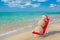 Sandy snowman in santa hat sunbathing in beach lounge.