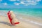 Sandy snowman in santa hat sunbathing in beach lounge.