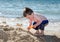 Sandy toddler digging at the beach