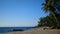 Sandy tropical beach over sea and blue summer sky background