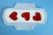 Sanitary pad With red hearts on blue. Personal hygiene, the concept of feminine hygiene. Critical days, blood period, menstrual