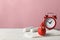 Sanitary pads with feather, decorative blood drop and alarm clock on wooden table