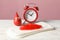 Sanitary pads with feather, decorative blood drop and alarm clock on wooden table