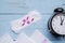 Sanitary pads with pills and alarm clock on table