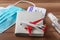 Sanitizer spray, face mask, plane toy and passport with ticket on the table