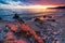 Sanremo, Riviera dei Fiori, Liguria, Italy. Scenis rocks and pebbles on beach illuminated beautiful by sunset light. Dramatic