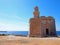 The Sant Nicolau Castle in ciutadella menorca on the cliffs with blue summer sea and blue sky