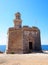 Sant Nicolau Castle in ciutadella menorca on the cliffs with blue summer sea and blue sky