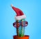 Santa cactus. Funky pop art minimal christmas in summer concept. Funny cactus with sunglasses and santa claus hat on bright pastel