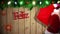 Santa carrying sack of gifts against festive wooden background