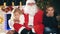 Santa and children around the decorated Christmas tree. Wishes