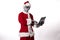 Santa Claus with alien mask wearing a tablet on a white background