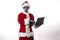 Santa Claus with alien mask wearing a tablet on a white background