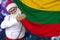 Santa Claus with a beard holds a beautiful colored national flag of the state of Lithuania on fabric, concept of tourism, New Year