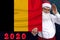 Santa Claus with a beard holds a beautiful photo of the colored national flag of the state of Belgium with festive date for 2020,