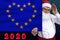 Santa Claus with a beard holds a beautiful photo of a stylized European Union flag with a festive date 2020, the concept of