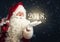 Santa Claus blowing magic snow of his hand, holding a year 2018