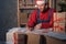 Santa Claus businessman sitting at his desk and scanning a delivery box with his mobile phone. Man selling products