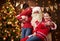 Santa Claus and child boy and girl posing together indoor near decorated xmas tree with lights, they talking, smiling and