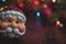 Santa Claus Christmas ornament in front of a decorative background with room for messaging.