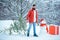 Santa Claus with Christmas tree. Happy winter time. Bearded man is carrying Christmas tree in the wood. Hipster woodsman