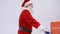 Santa Claus in costume singing and pushing shopping trolley