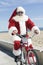Santa Claus Cycling By Beach