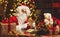 Santa Claus at desk with letters, gifts near Christmas tree