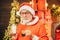 Santa Claus enjoys cookies and milk left out for him on Christmas eve. Cheerful Santa Claus holding glass with milk and
