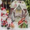 Santa Claus figurines in front of a snowy house