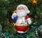 Santa Claus with gifts plastic among the green pine needles with the lights illumination. Christmas, Toys, New year