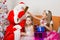 Santa Claus gives gifts to one girl, other sitting in the waiting