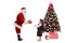 Santa Claus giving a present to a schoolgirl next to a Christmas
