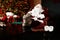 Santa Claus with glass of milk resting near Christmas tree, focus on legs