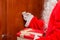 Santa Claus handing gift box and knocking door