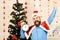 Santa Claus with happy winners face near Christmas tree