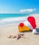 Santa Claus hat and christmas gift box on the seashore with sea