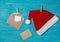 Santa Claus hat and envelope with a letter on clothespins, on a clothesline. Blue wooden background