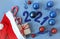 Santa Claus hat with gifts and festive caramel, Christmas balls and numbers 2021, blue background, top view