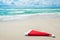 Santa Claus hat on seashore against waves