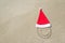 Santa Claus hat and smiley face on seashore against waves